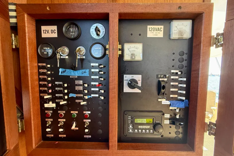 Slide: The Image of Electrical panel of 1985 Chris-Craft 382 Commander boat, featuring 12V DC and 120V AC controls. - 34