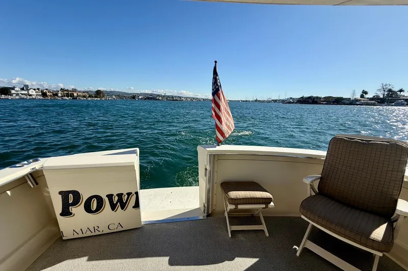 Slide: The Image of 1985 Chris-Craft 382 Commander boat deck with American flag, ocean view, and seating. - 36