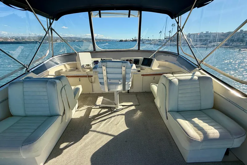 Slide: The Image of 1985 Chris-Craft 382 Commander yacht interior with helm and seating, overlooking marina. - 39