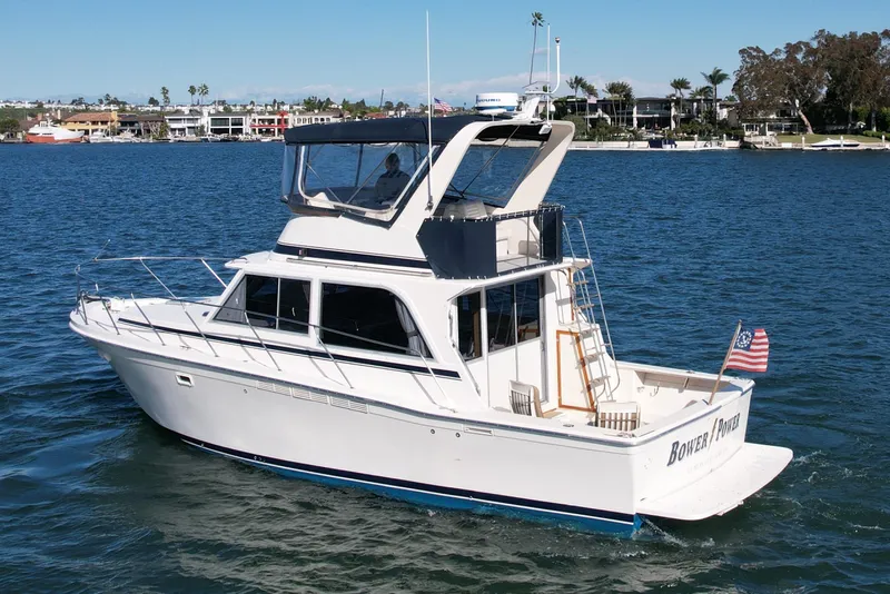 Slide: The Image of 1985 Chris-Craft 382 Commander yacht cruising on a sunny day in a scenic harbor. - 4