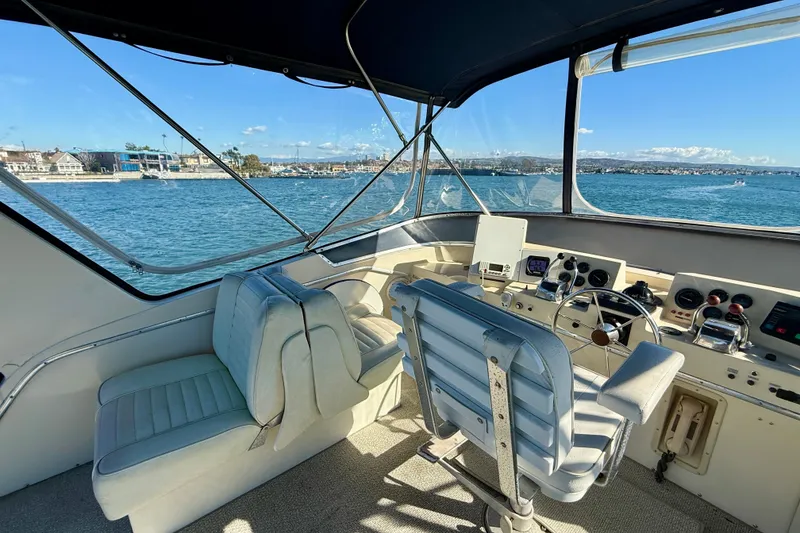 Slide: The Image of 1985 Chris-Craft 382 Commander helm with ocean view, featuring classic controls and seating. - 41