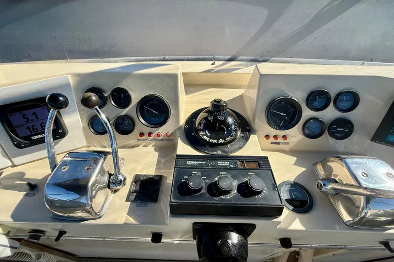 Slide: The Image of Control panel of a 1985 Chris-Craft 382 Commander boat with gauges and levers. - 44
