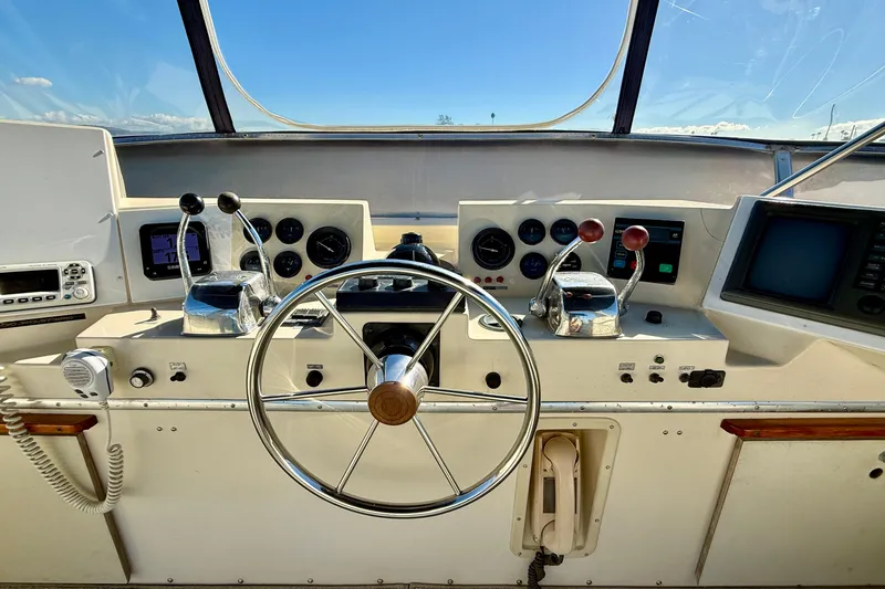 Slide: The Image of 1985 Chris-Craft 382 Commander helm with steering wheel, controls, and navigation instruments. - 48
