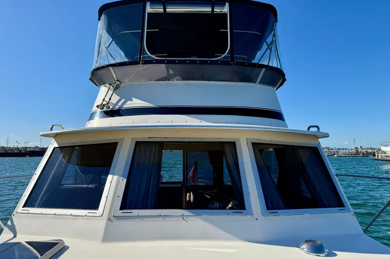 Slide: The Image of 1985 Chris-Craft 382 Commander yacht on water, showcasing upper deck and windows. - 51