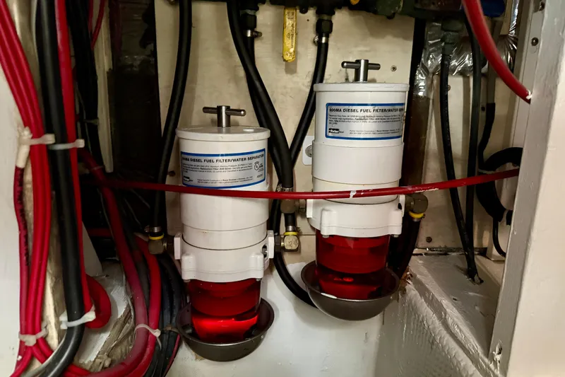 Slide: The Image of 1985 Chris-Craft 382 Commander engine room with dual diesel fuel filters and red wiring. - 55