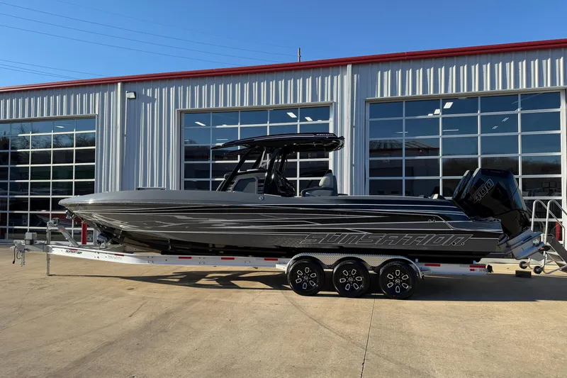 The Image of 2026 Sunsation 32CCX boat on trailer, parked outside a modern building. - 0