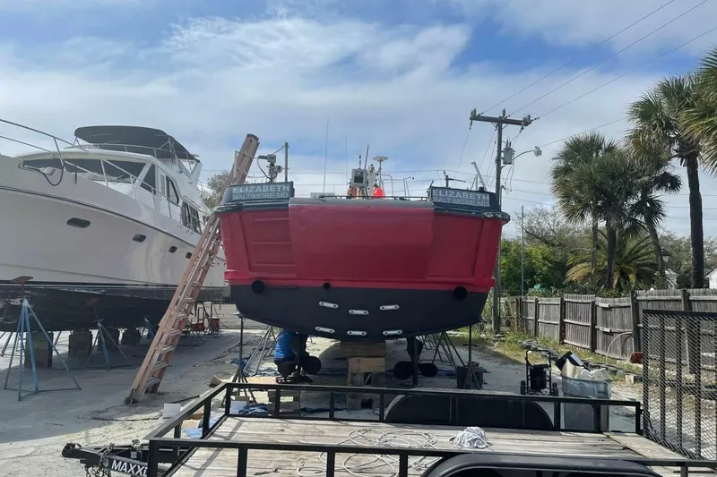 Slide: The Image of Red commercial boat "Elizabeth" from 1964 in a boatyard, alongside another vessel. - 3