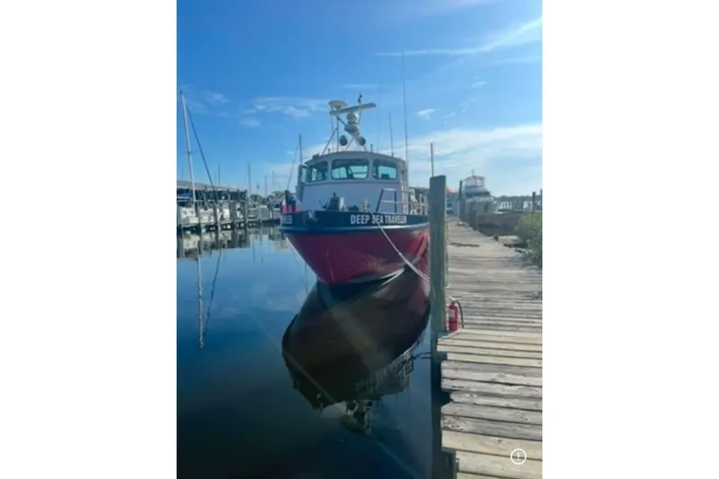 Slide: The Image of 1964 custom commercial boat "Deep Sea Traveler" docked at a marina under clear blue skies. - 6