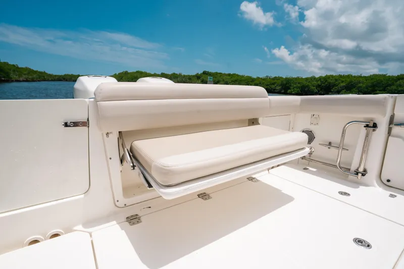 Slide: The Image of 2019 Boston Whaler 330 Outrage boat with foldable seating, under clear blue sky. - 18