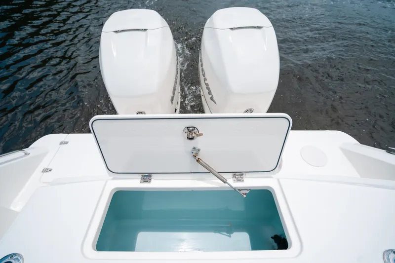 Slide: The Image of 2019 Boston Whaler 330 Outrage with open storage compartment and twin outboard engines. - 20