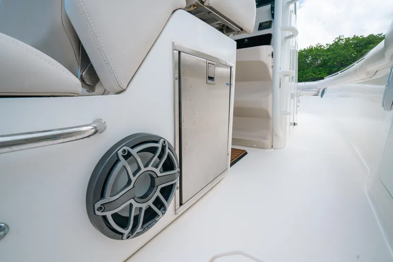 Slide: The Image of 2019 Boston Whaler 330 Outrage interior with speaker and storage compartment. - 21