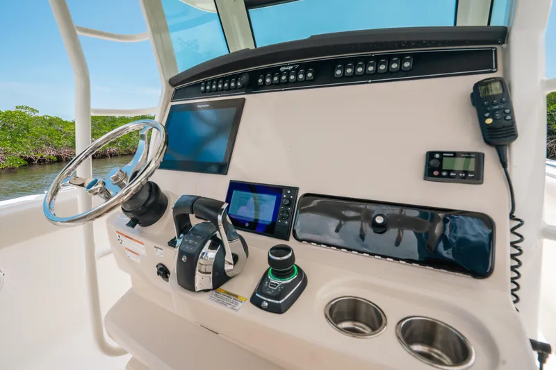 Slide: The Image of 2019 Boston Whaler 330 Outrage helm with steering wheel, controls, and navigation screens. - 5