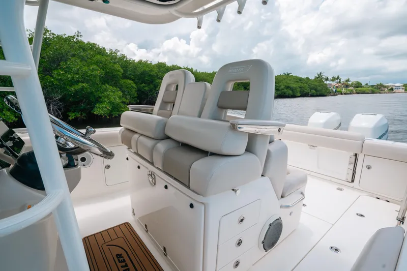 Slide: The Image of 2019 Boston Whaler 330 Outrage boat interior with plush seating and steering wheel. - 7