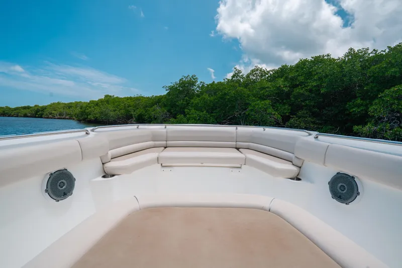 Slide: The Image of 2019 Boston Whaler 330 Outrage boat interior with cushioned seating and speakers, under blue sky. - 9
