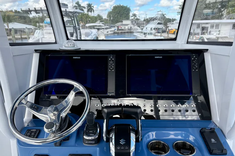 Slide: The Image of 2026 NauticStar 332 Offshore helm with dual Simrad displays and modern controls. - 12