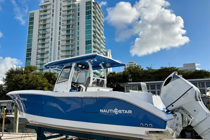 Slide: The Image of 2026 NauticStar 332 Offshore boat docked with cityscape background. - 14