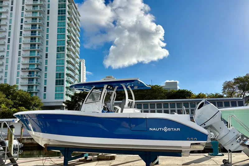 Slide: The Image of 2026 NauticStar 332 Offshore boat docked near modern high-rise buildings. - 15