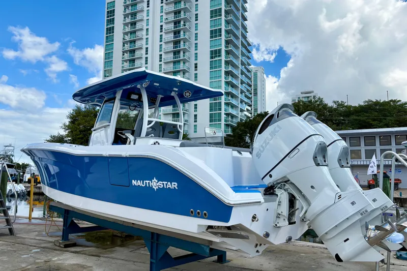 Slide: The Image of 2026 NauticStar 332 Offshore boat with dual engines, docked near modern high-rise buildings. - 4