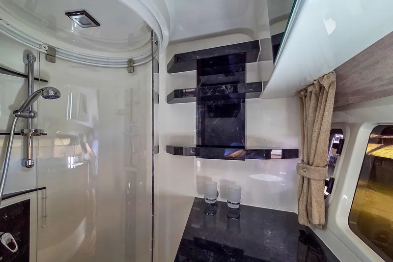 Slide: The Image of 2026 Marex 330 Scandinavia boat with sleek white deck and wooden accents at a boat show. - 25