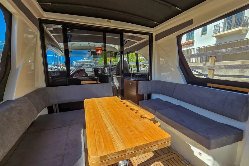 Slide: The Image of 2026 Marex 330 Scandinavia yacht interior with sleek seating and wooden table. - 11