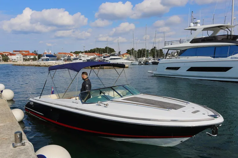 Slide: The Image of 2004 Chris-Craft Corsair 28 boat docked in a marina with clear skies. - 2