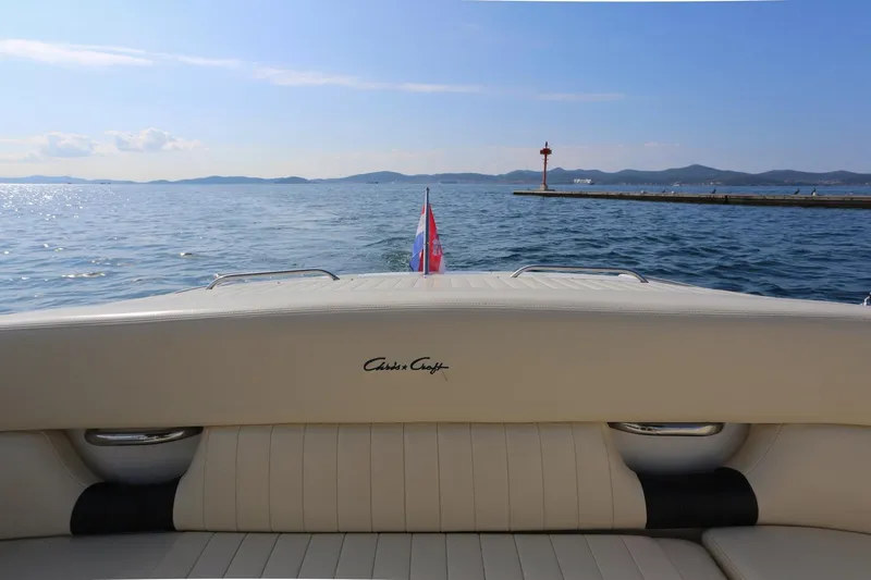 Slide: The Image of 2004 Chris-Craft Corsair 28 boat on calm sea with distant mountains. - 3