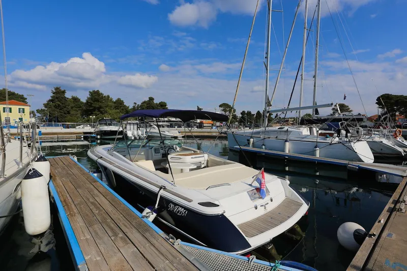 Slide: The Image of 2004 Chris-Craft Corsair 28 docked in a marina under a blue sky. - 5