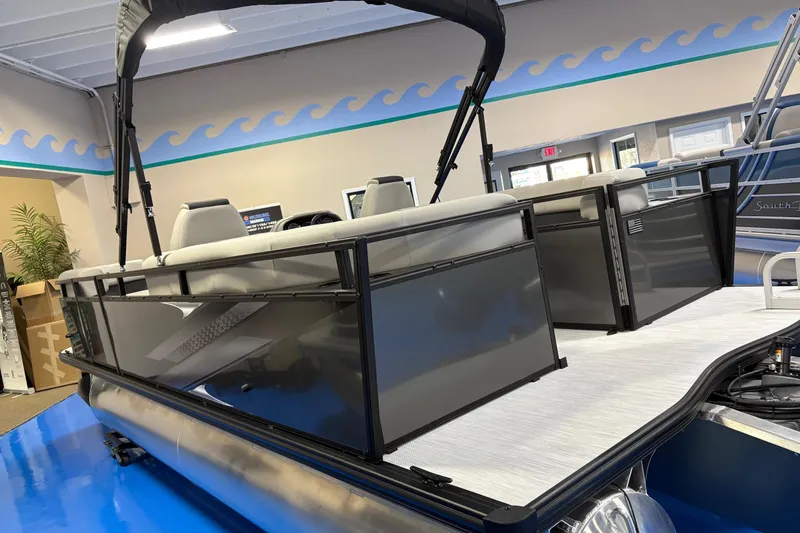 Slide: The Image of 2026 Dockside 22DQ pontoon boat with sleek design in showroom setting. - 2