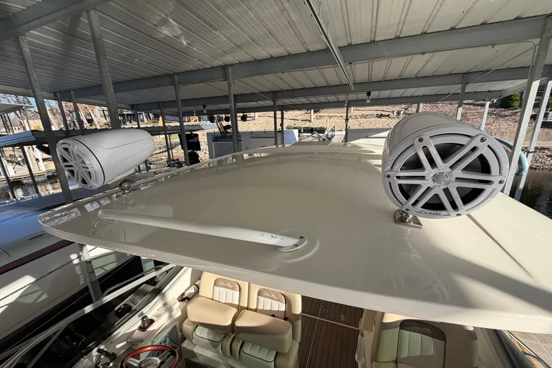 Slide: The Image of 2014 Sea Ray 370 Sundancer with mounted speakers on deck under covered dock. - 11
