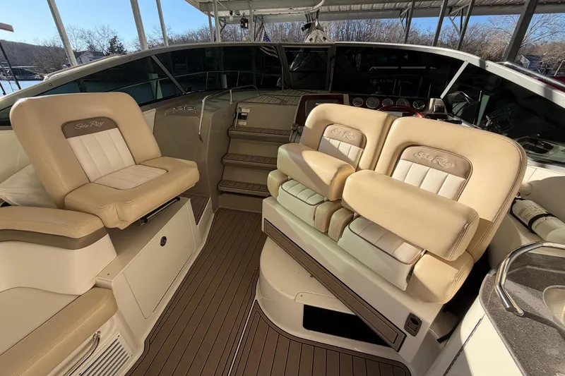 Slide: The Image of 2014 Sea Ray 370 Sundancer cockpit with beige seating and helm controls. - 19