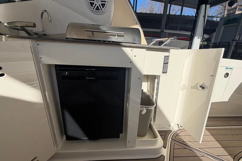 Slide: The Image of 2014 Sea Ray 370 Sundancer boat kitchen with sink, grill, and storage. - 27