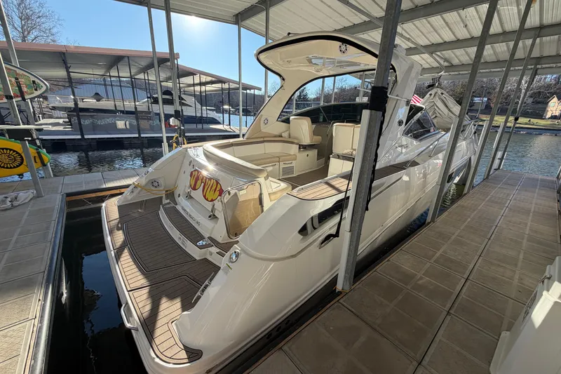 Slide: The Image of 2014 Sea Ray 370 Sundancer docked in a marina under a covered slip. - 3