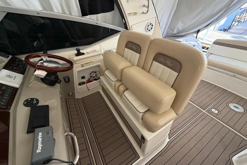 Slide: The Image of 2014 Sea Ray 370 Sundancer helm with beige seating and wood-accented steering wheel. - 32