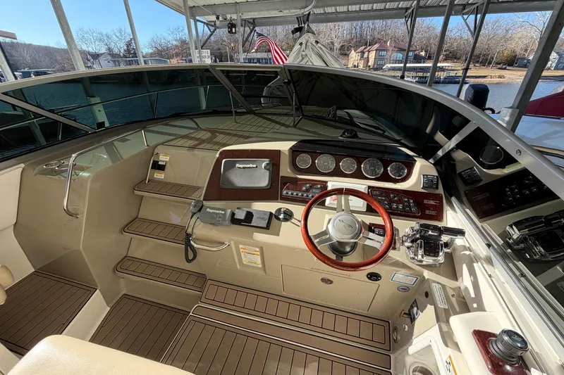 Slide: The Image of 2014 Sea Ray 370 Sundancer helm with wood accents and modern navigation equipment. - 33