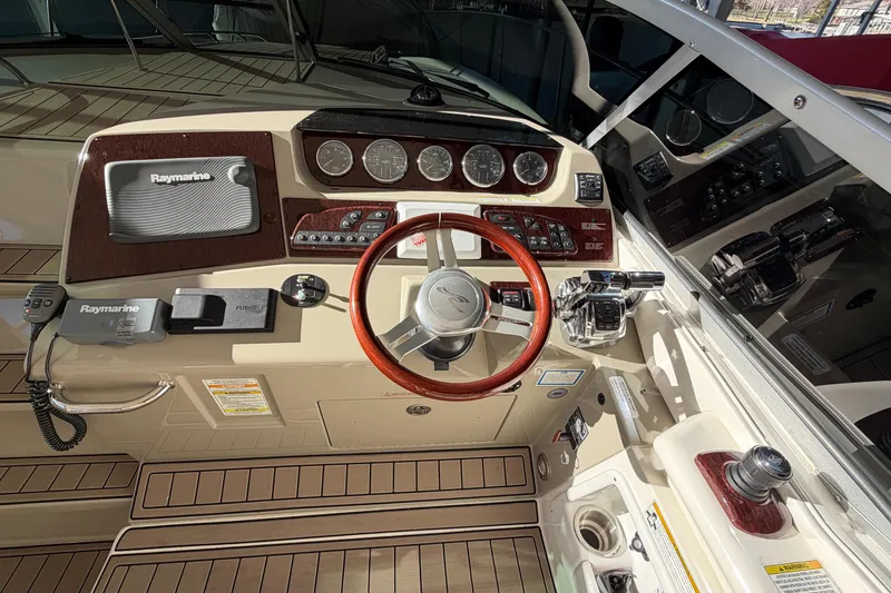 Slide: The Image of 2014 Sea Ray 370 Sundancer helm with Raymarine electronics and wood-accented steering wheel. - 36