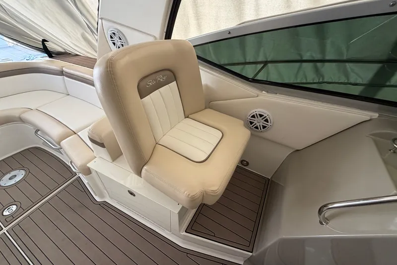 Slide: The Image of 2014 Sea Ray 370 Sundancer cockpit with beige seating and wood-style flooring. - 42