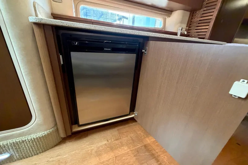 Slide: The Image of Interior of 2014 Sea Ray 370 Sundancer showing a compact stainless steel refrigerator. - 51