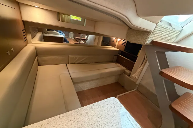 Slide: The Image of Interior of 2014 Sea Ray 370 Sundancer with beige seating and wooden stairs. - 58