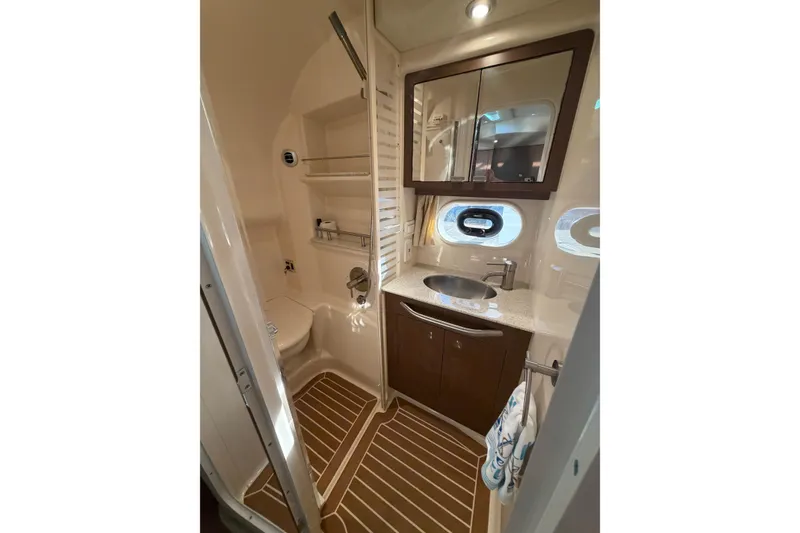 Slide: The Image of Luxurious bathroom in 2014 Sea Ray 370 Sundancer yacht with modern fixtures and wood accents. - 61