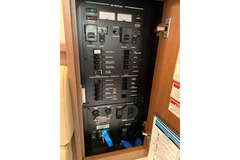 Slide: The Image of Electrical panel inside 2014 Sea Ray 370 Sundancer boat, showing switches and controls. - 63