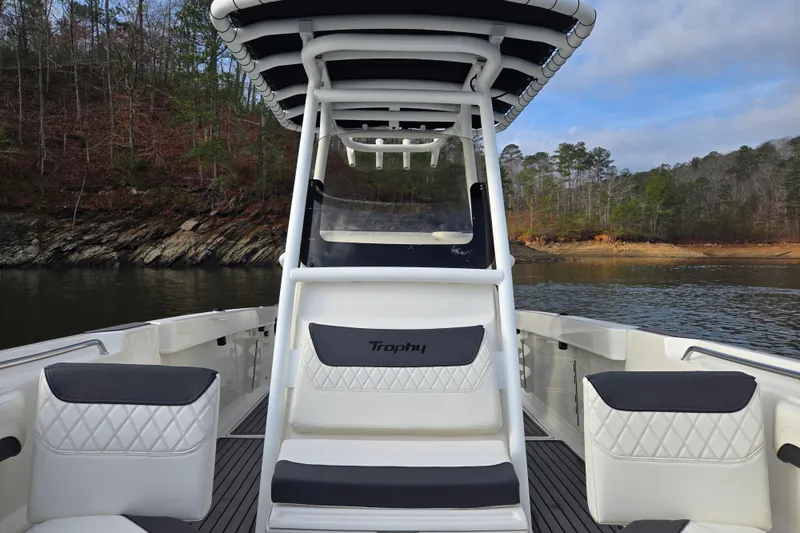 Slide: The Image of 2023 Bayliner Trophy T24CC boat interior with seating, on a scenic lake. - 12