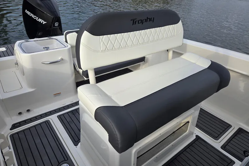 Slide: The Image of 2023 Bayliner Trophy T24CC boat interior with cushioned seating and Mercury engine. - 13