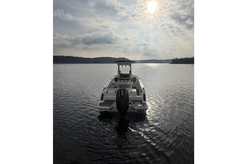 Slide: The Image of 2023 Bayliner Trophy T24CC boat on calm water under a cloudy sky. - 4