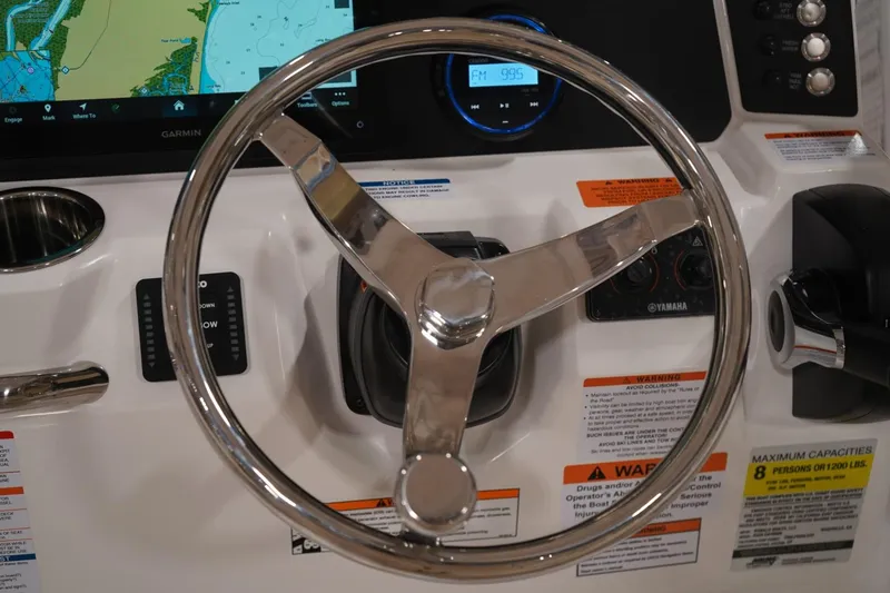 Slide: The Image of Steering wheel and controls of 2026 Robalo 226 Cayman boat with navigation display. - 10