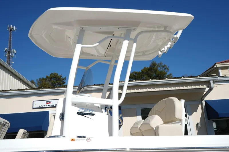 Slide: The Image of 2026 Robalo 226 Cayman boat with T-top and seating, displayed outdoors. - 2