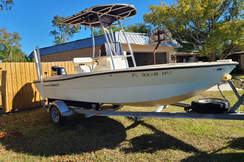 The Image of 1994 Key West 1900 Sportsman boat on trailer, parked in a sunny yard. - 0