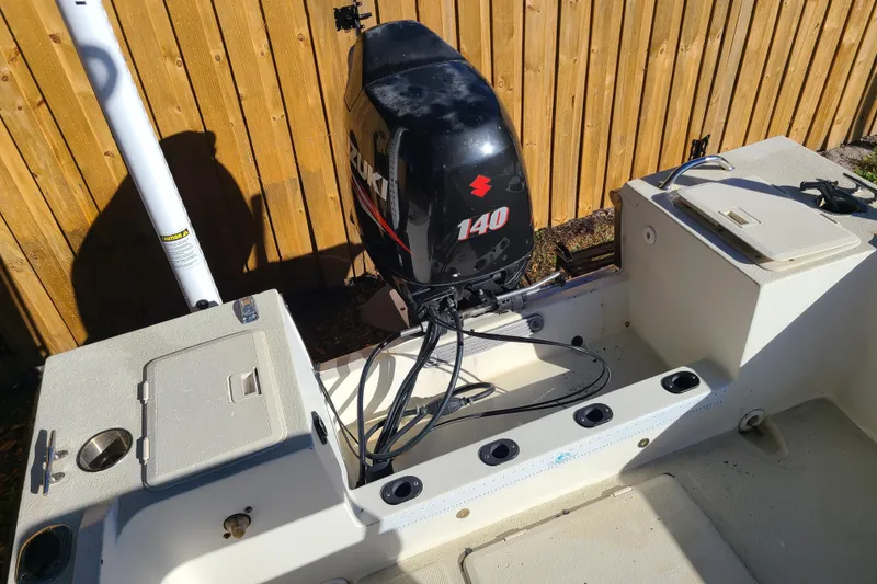 Slide: The Image of 1994 Key West 1900 Sportsman boat with Suzuki 140 outboard motor, docked near wooden fence. - 11