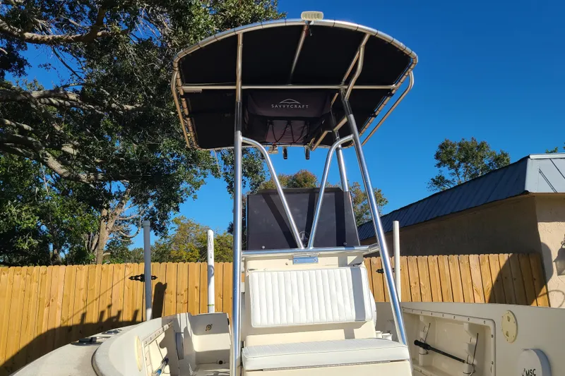 Slide: The Image of 1994 Key West 1900 Sportsman boat with T-top, parked outdoors under clear blue sky. - 5
