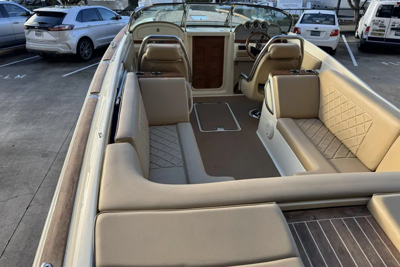 Slide: The Image of 2016 Chris-Craft Corsair 25 boat interior with beige seating and wood accents. - 14
