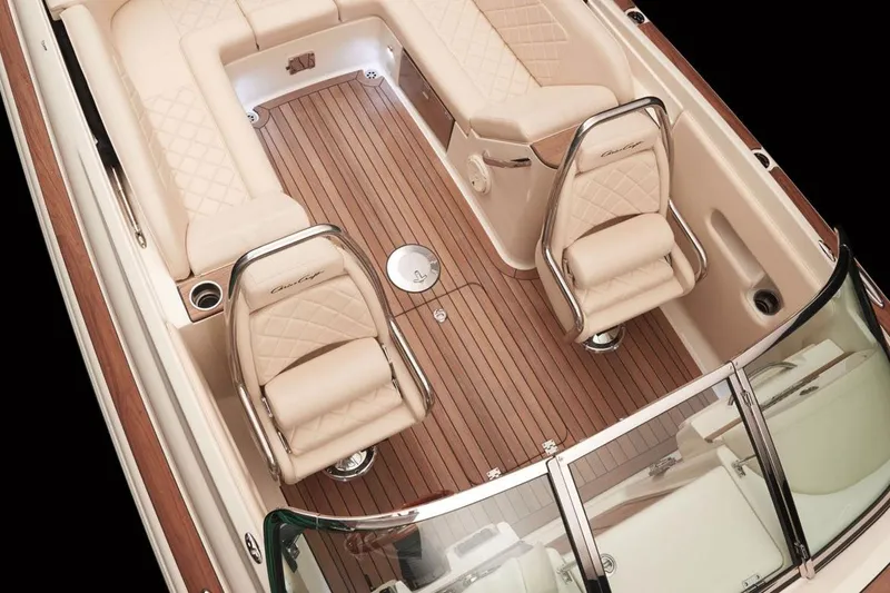 Slide: The Image of Manufacturer Provided Image: 2016 Chris-Craft Corsair 25 boat interior with beige leather seats and wooden flooring. - 3